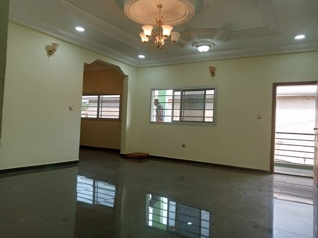 Spacious living room with chandelier, wall sconces and polished tile floor